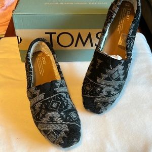 Two pairs of Toms size W11 slip on women’s shoes.